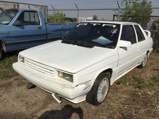 Selling Off-Site - 527 North 200 East, Raymond, AB -  1987 Renault GTA. Auto, S/N 1XMVW9673HK115068. Note: No Keys, Kms Unknown, Running Condition Unknown.
