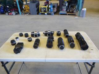 (1) Nikon Camera, (1)  Pentax Camera and a Box of Assorted Lenses (G1)