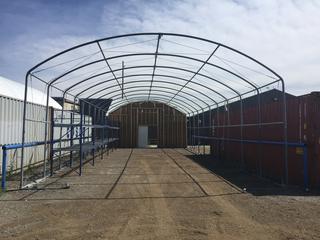Steel Single Truss Storage Tent Frame c/w Wood End Wall, 25' x 60' x 14'8". Note: Buyer is responsible for dismantling and removal. Frame is currently standing in Century's Regional Auction Centre, High River