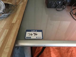 Selling Off- Site -  31"x60" Glass & Steel Table.  Location - 527 North 200 East, Raymond, AB -  For Further Information Please Call Chris 403-308-1161.