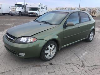 2004 Chev Optra 4 Door Hatchback Car c/w 2.0L 4 Cyl, Auto, A/C, 195/55R1585H Tires, Showing 209,484 Kms, VIN KL1JK62Z84K982200. *Note: Missing Passenger Side Fan Cover, Center Console Broken, Spare Tire On Passenger Rear, Scratches On Bumper, Old Battery, Stained Seats, Runs & Drives