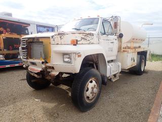 1987 Ford F700 Flat Deck 4X4 S/A  Tank Truck c/w 8.2L Detroit Diesel, 5-Spd Manual, 24,000lb GVWR, 7ft X 93in X 4ft Water Tank, 172in WB And 9.00R20 Tires. Showing 121,876kms. VIN 1FDNK77N2HVA28290 *Note: Front Grille Broken/Missing, Running Condition Unknown* *PL#99* (LOCATED IN ACHESON)